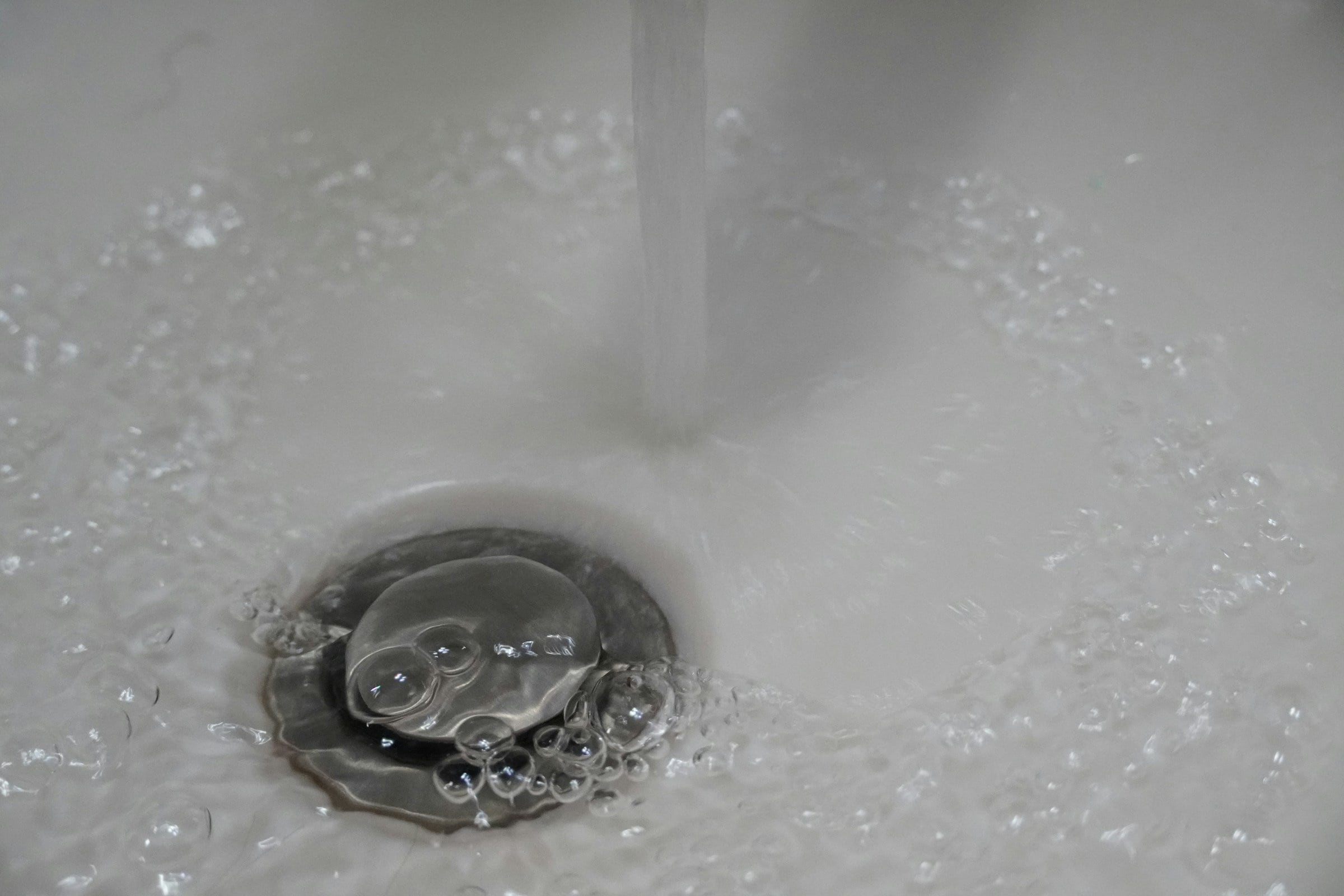 Water draining slowly into a sink plughole
