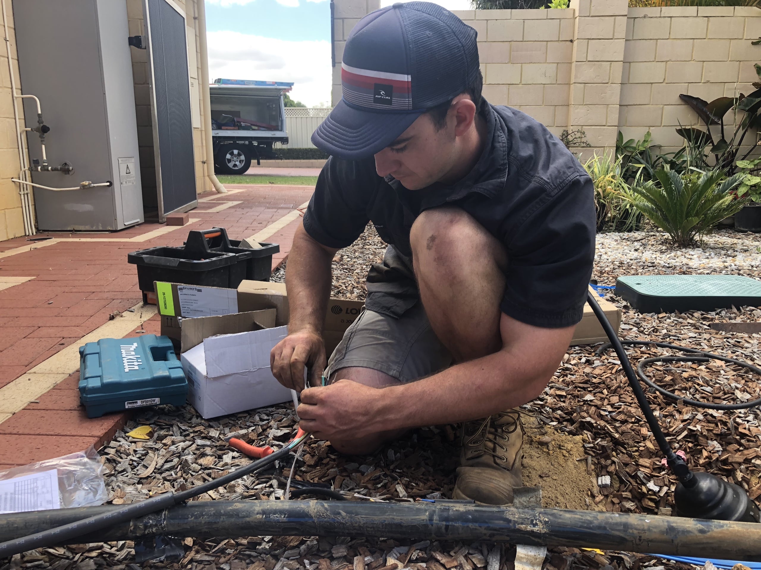 Riverside plumber working on the wiring of a garden bore pump in Perth
