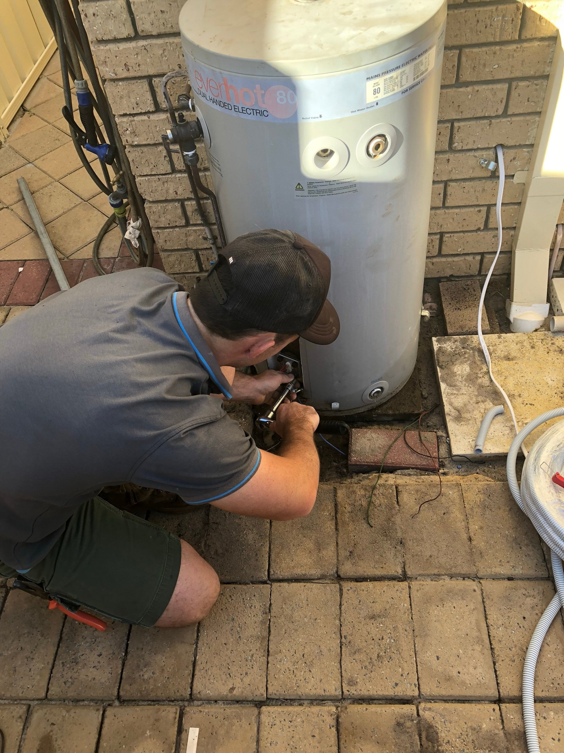 Riverside plumber servicing an electric storage hot water system at a Perth home