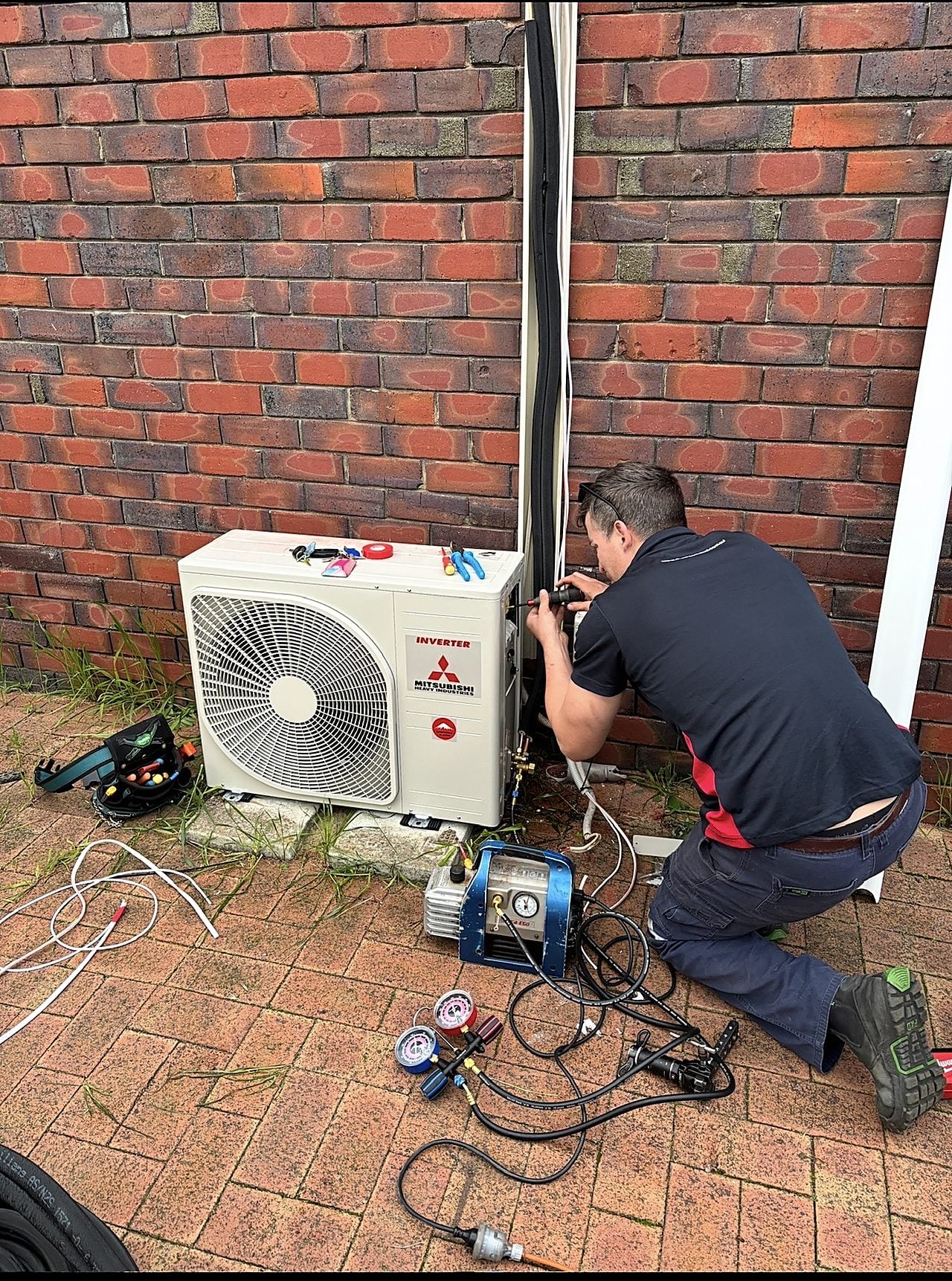 A technician diagnosing an air conditioning fault on an outdoor unit