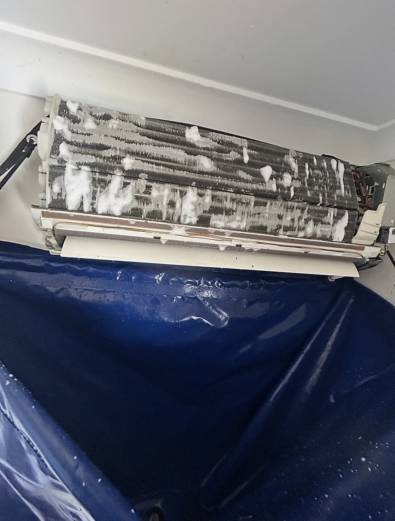 A split system indoor unit being deep-cleaned during a service