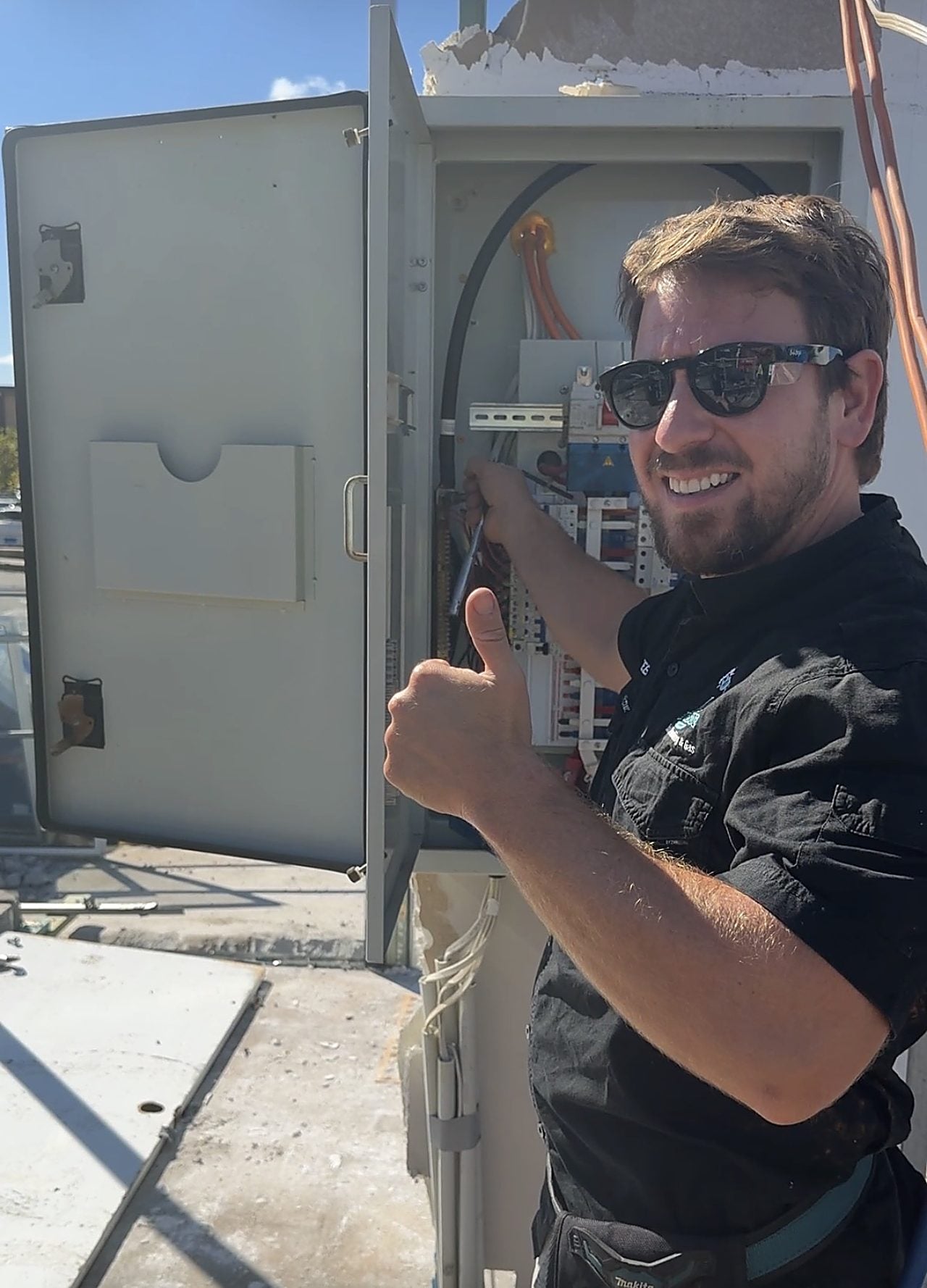 A Riverside electrician at an open switchboard during a residential job in Perth