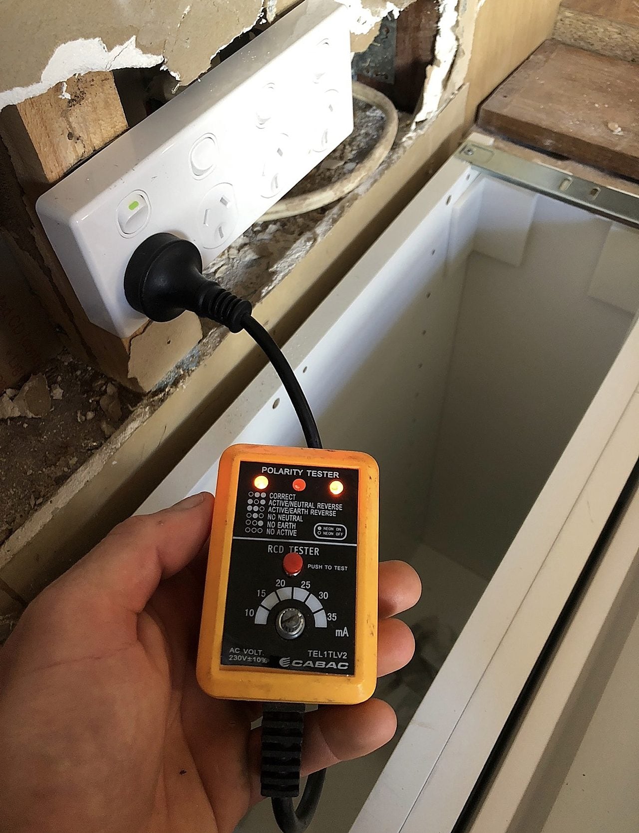 An electrician using a meter to trace an electrical fault on a circuit